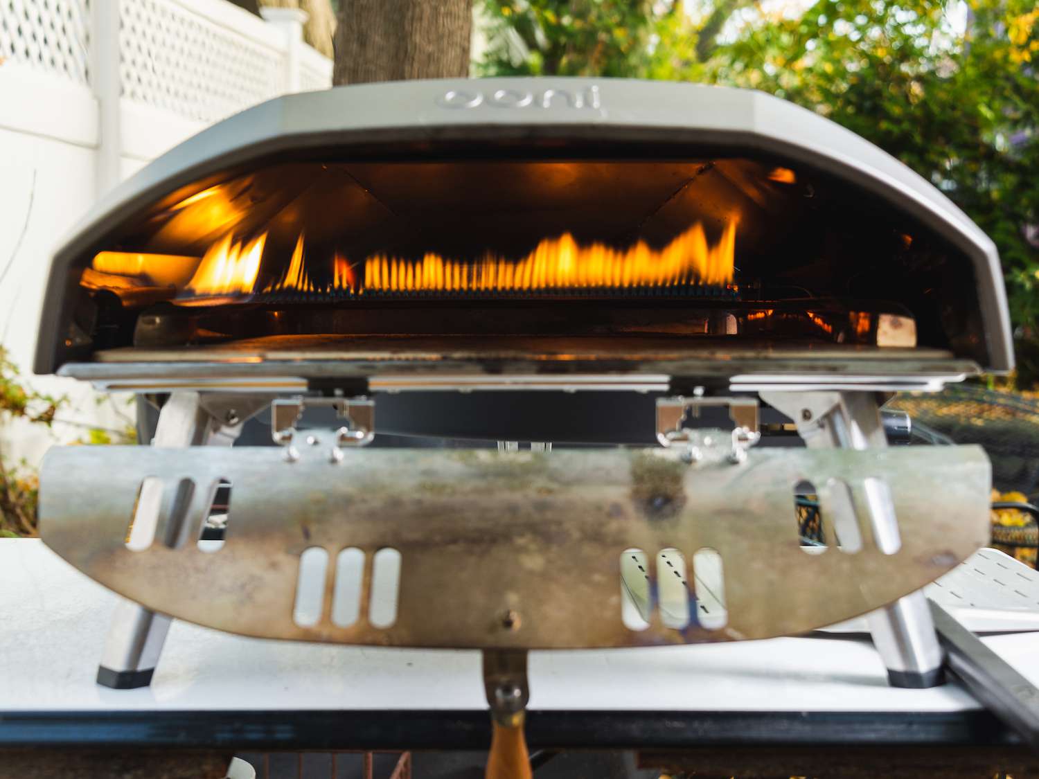 Looking into the mouth of a lit outdoor pizza oven 