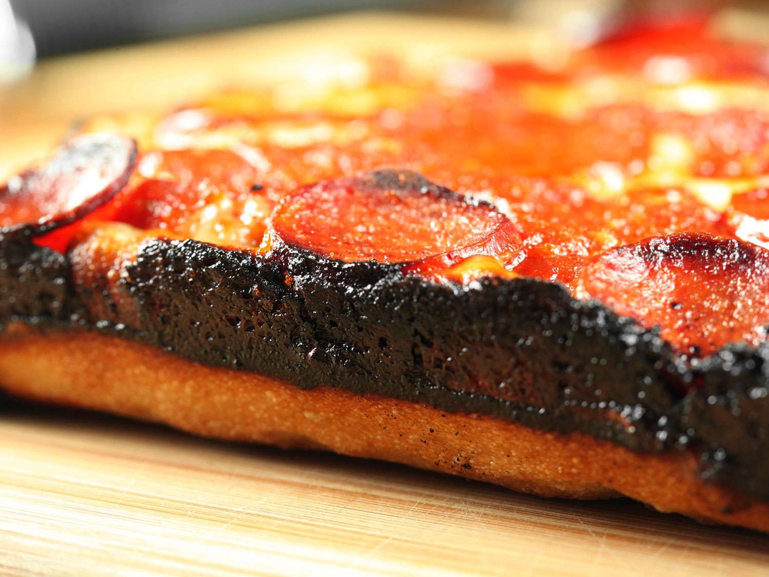 Crisp cheese cooked onto the edge of a Detroit-style pizza.