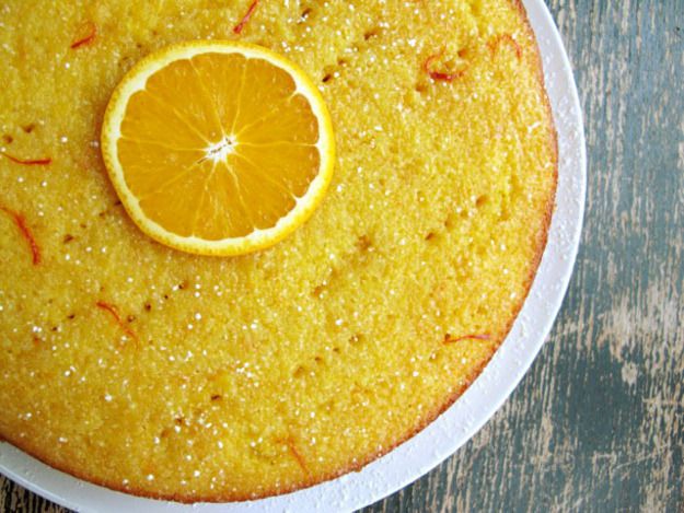 Overhead of bright yellow flourless orange-saffron cake for Rosh Hashanah.