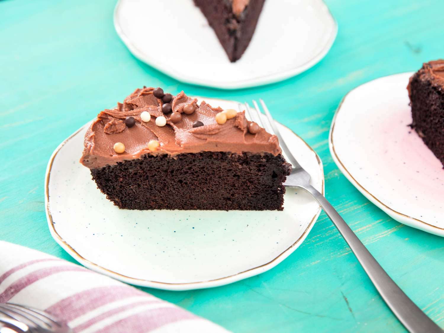 A slice of chocolate skillet cake with milk-chocolate ganache on a plate.