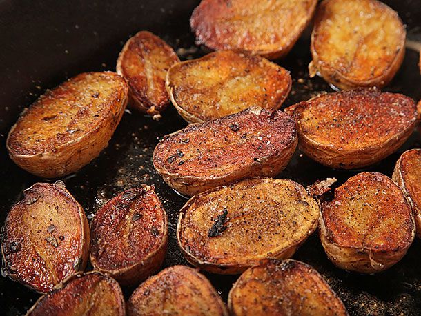 Crisping fingerling potato halves to deep golden brown in skillet.