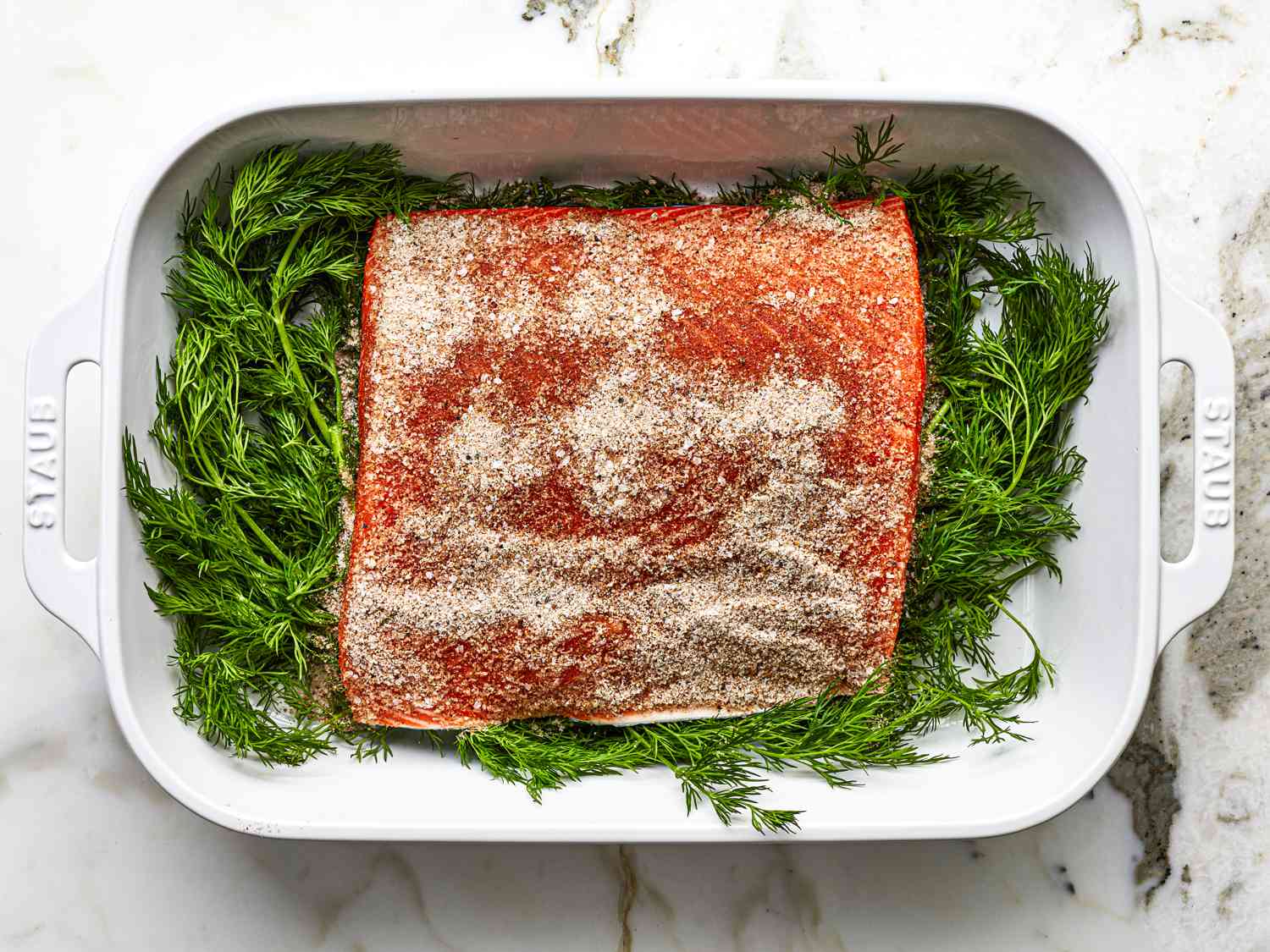Salmon, skin side down, on a bed of dill