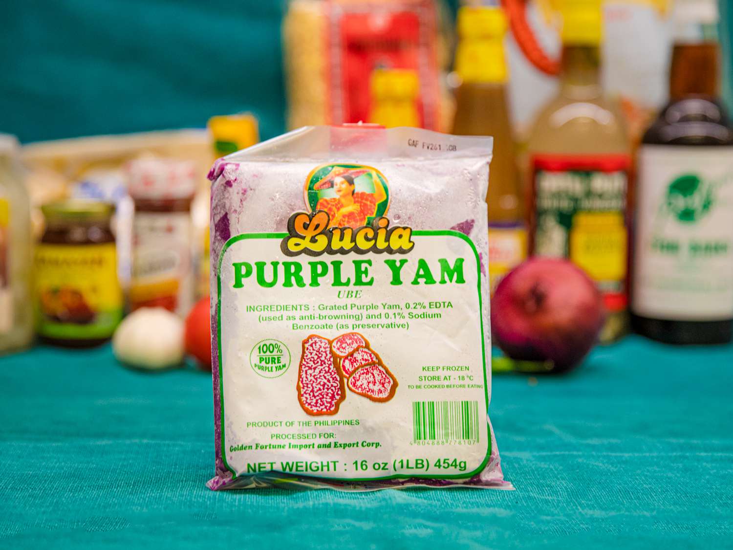 A packet of frozen Lucia brand Purple Yam on a blue backdrop