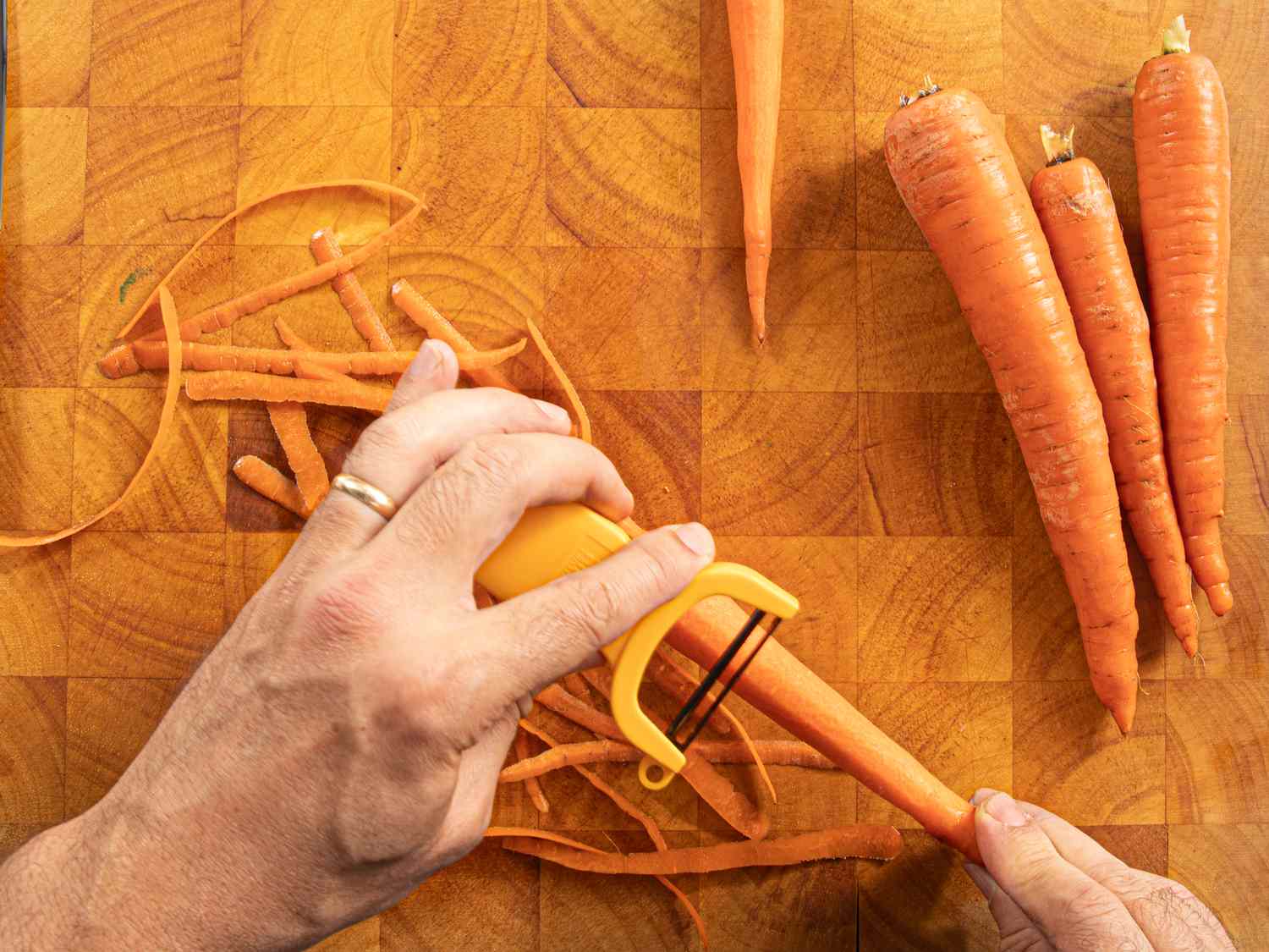 Overhead view of peeling carrots