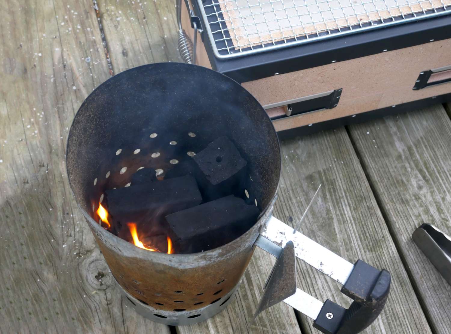 a charcoal chimney with ignited binchotan inside
