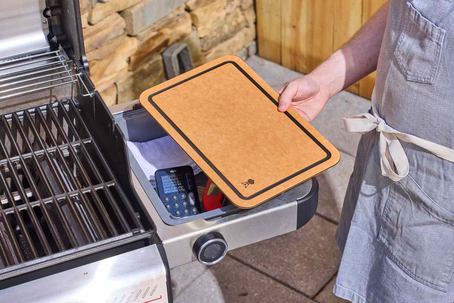 A person holding a board from the Weber Spirit EP-435 Gas Grill
