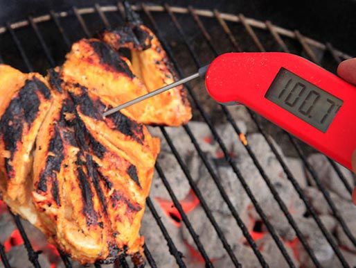 Taking the temperature of grilling tikka chicken.