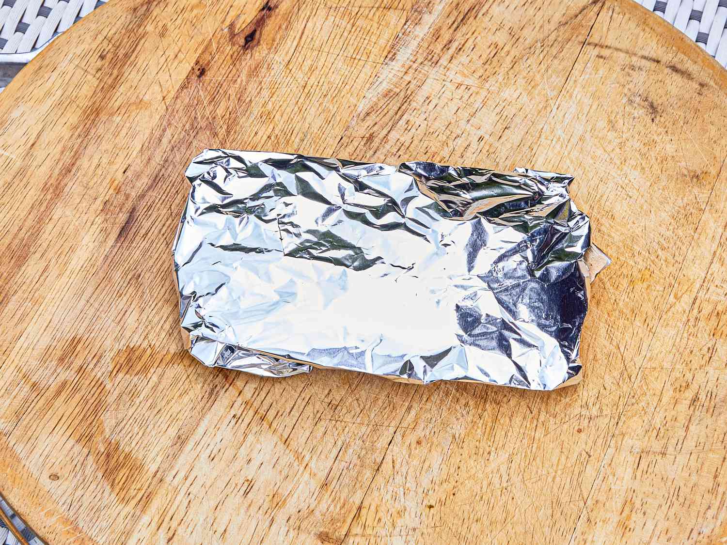 Wrapped aluminum foil parcel on a wooden surface