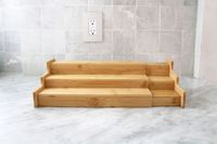 A tiered bamboo shelf organizer on a kitchen countertop