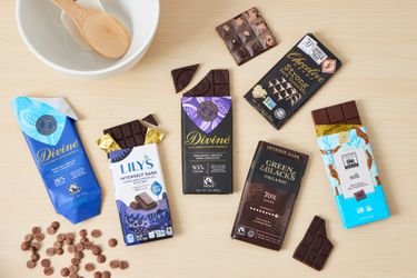 Numerous chocolate bars on a wooden countertop.