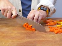 a person cutting up carrots with the Made In santoku