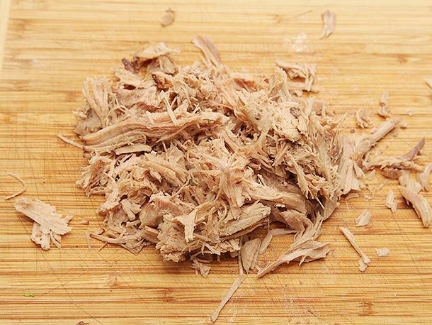 Shredded turkey meat on a cutting board. 