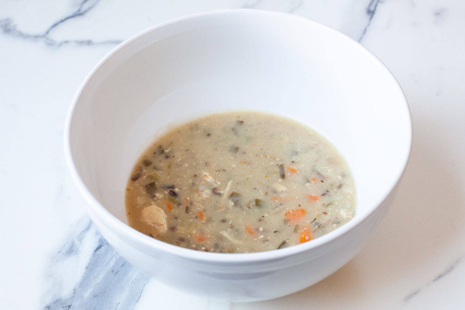 A large bowl with a serving of soup in it