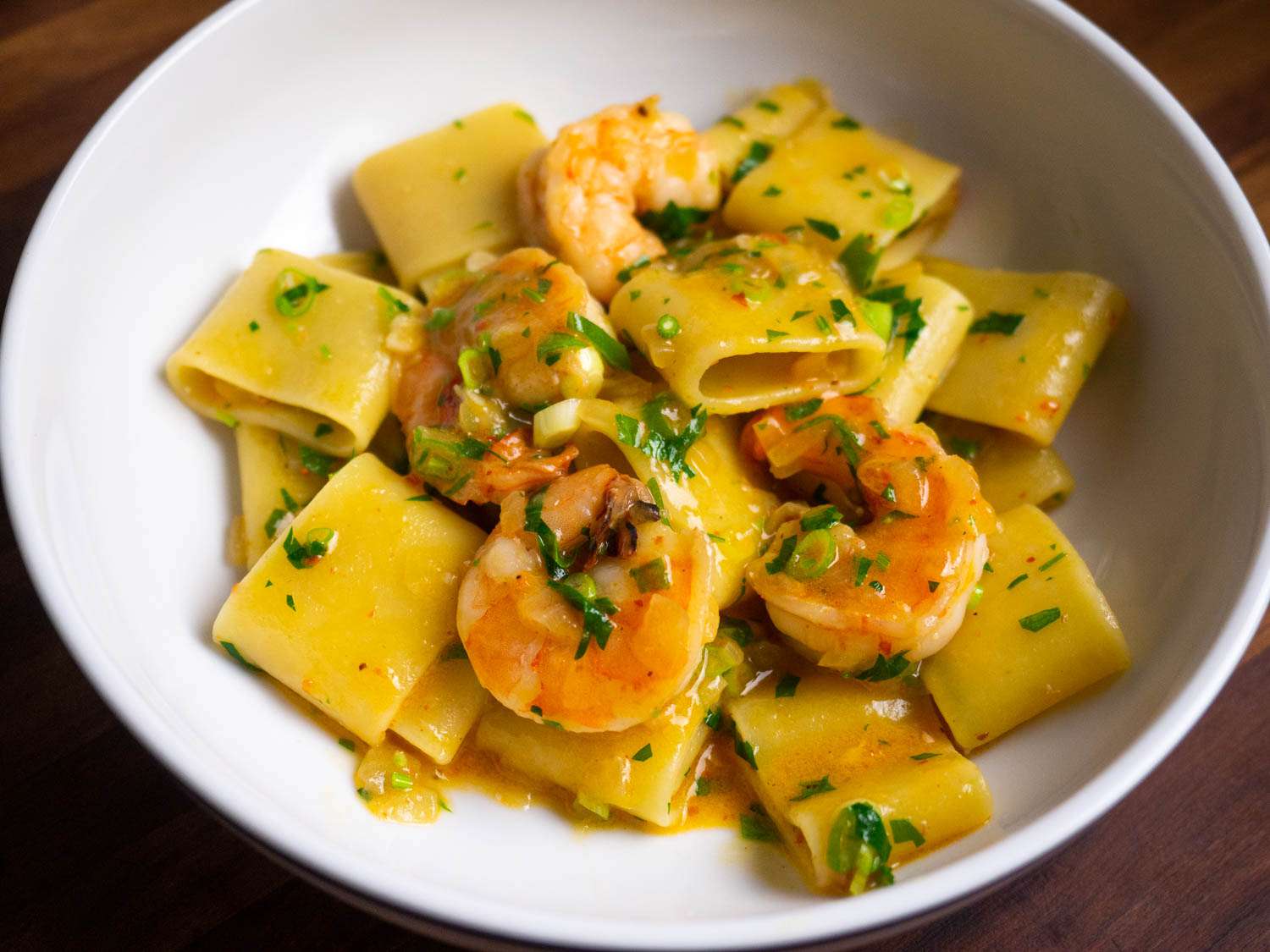 A plate of shrimp pasta, showing a red stain to the butter-and-oil sauce, all thanks to a hefty dose of chile powder, some of which was very spicy, and some of which was mild