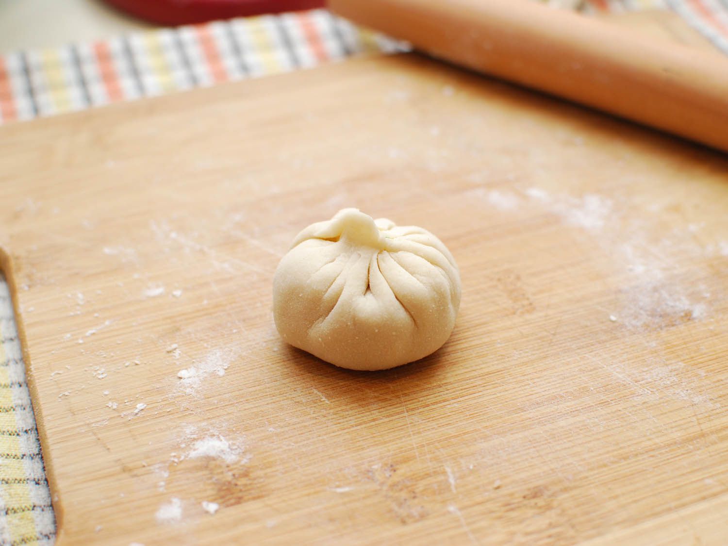 A wrapped sheng jian bao, ready to be cooked.