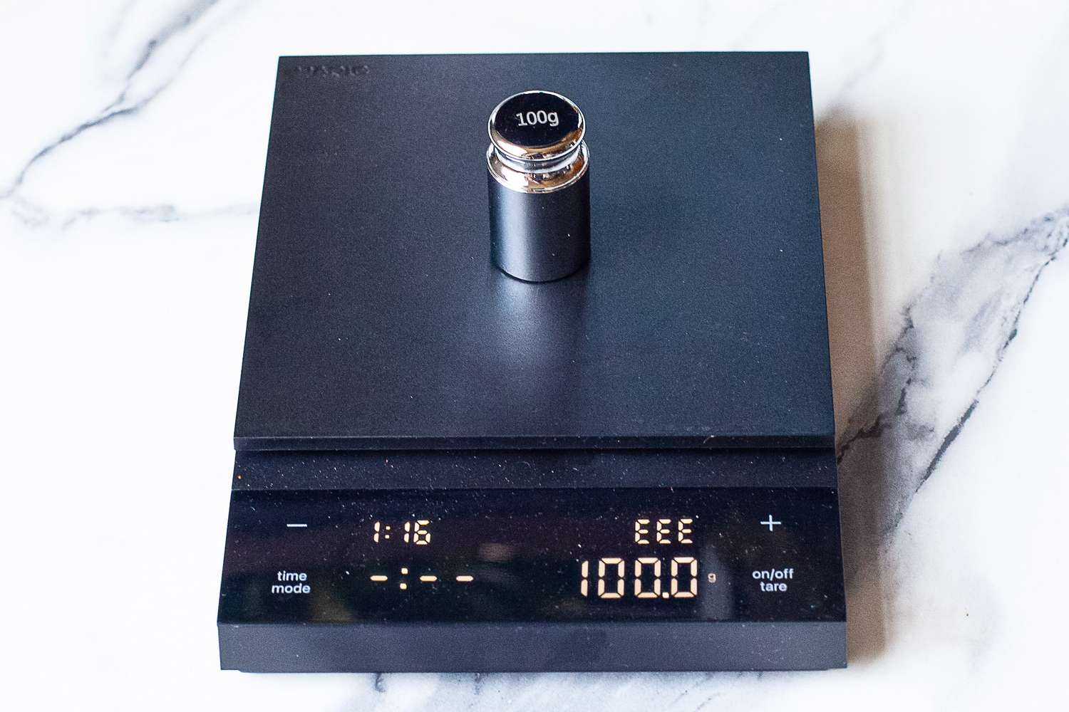 Hario Polaris Coffee Scale with a 100g calibration weight on it