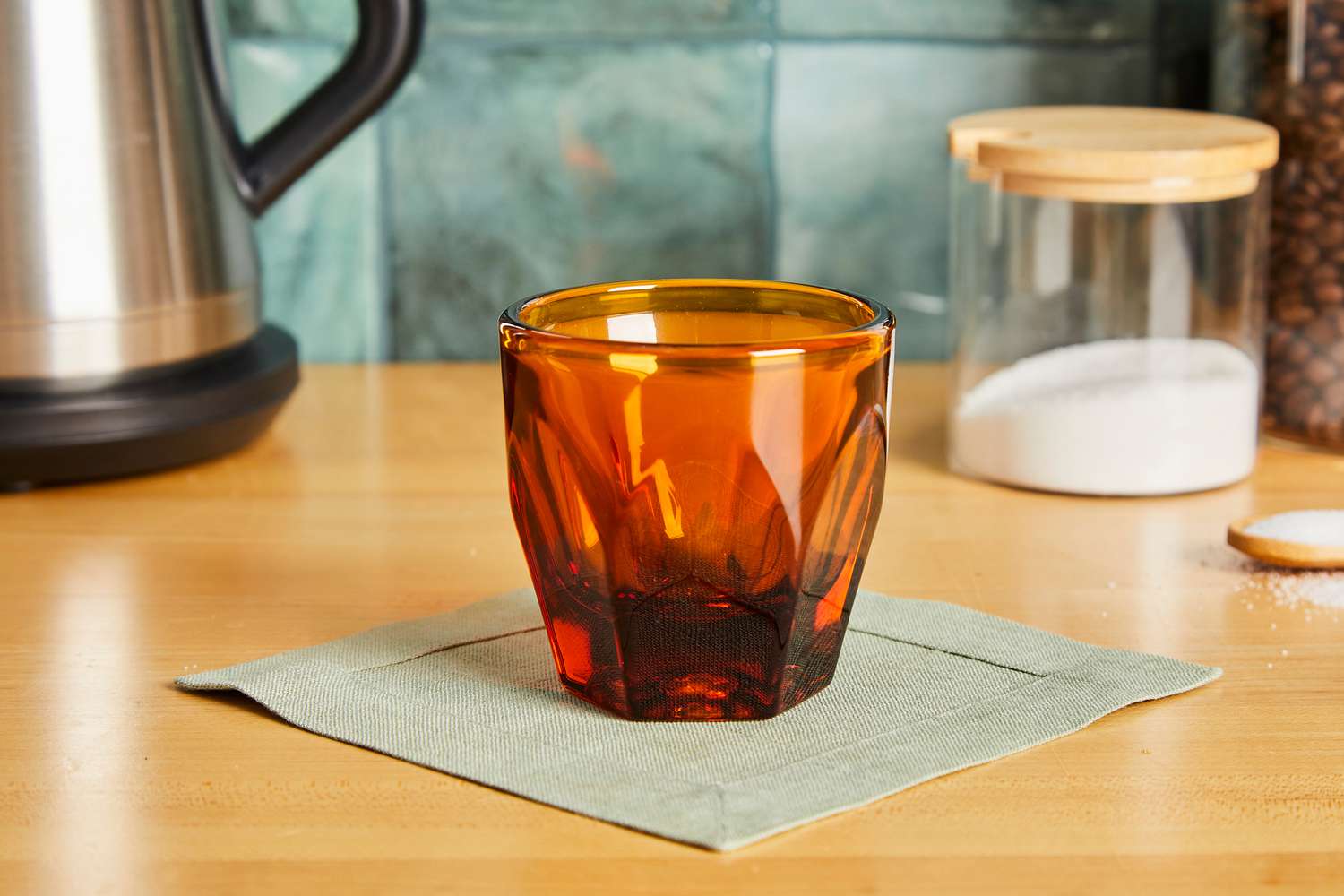 An amber cortado glass on a kitchen countertop.