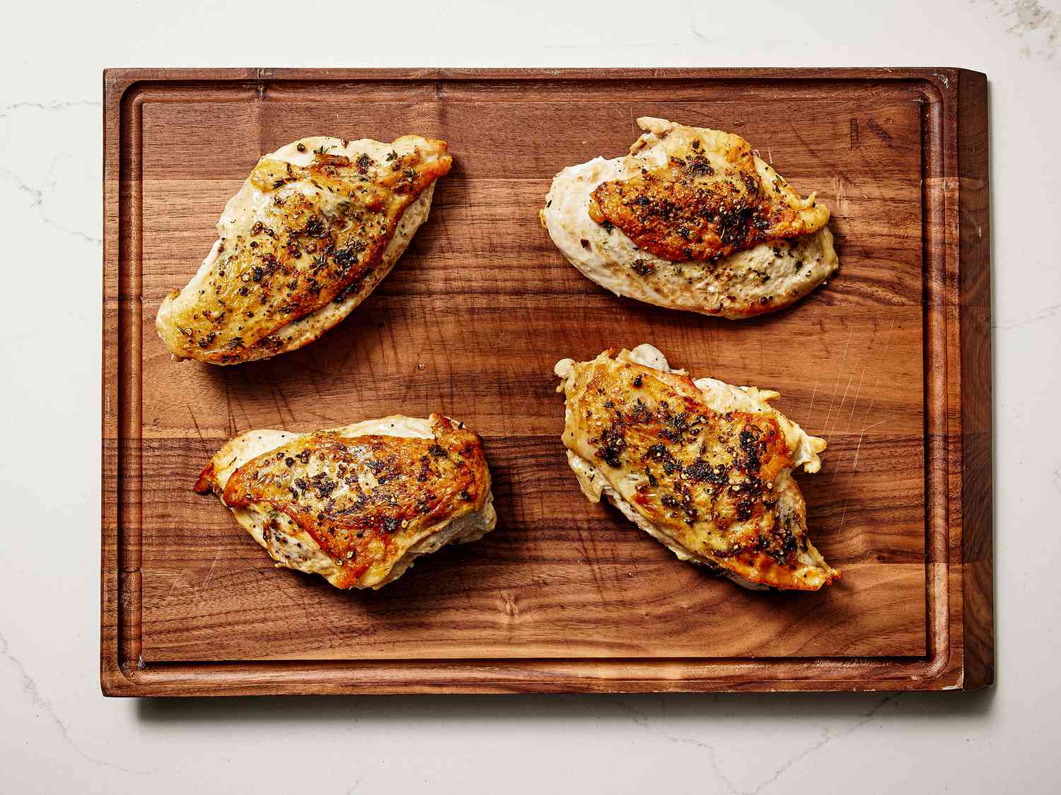 Chicken transferred onto a wooden cuttingboard. 