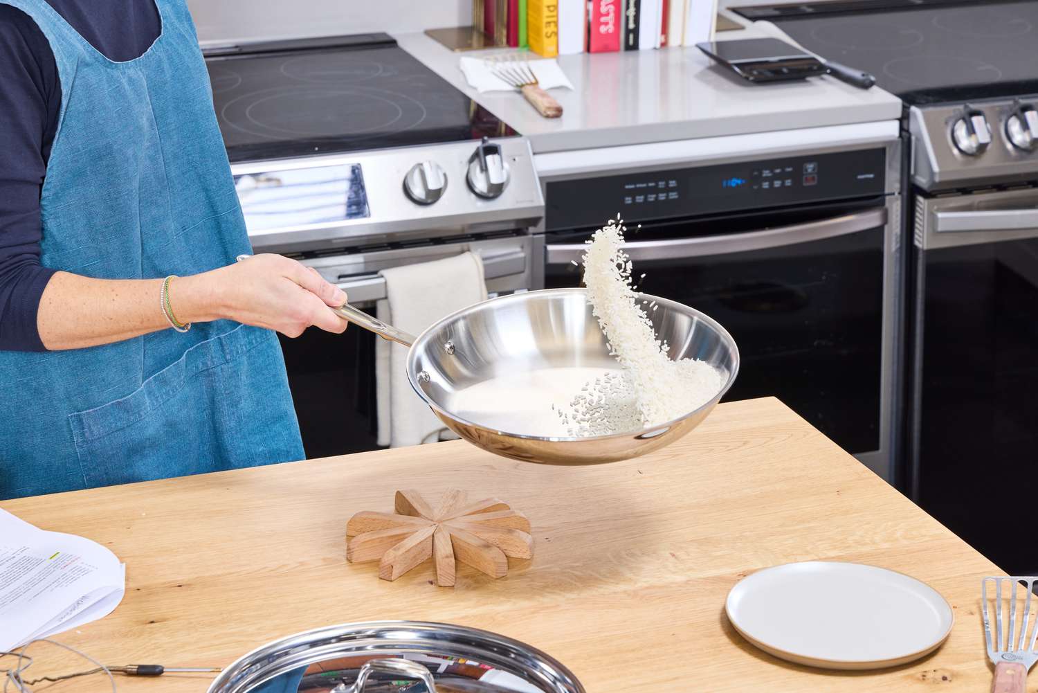 A person flips rice in the All-Clad D3 Stainless-Steel 12-Inch Fry Pan