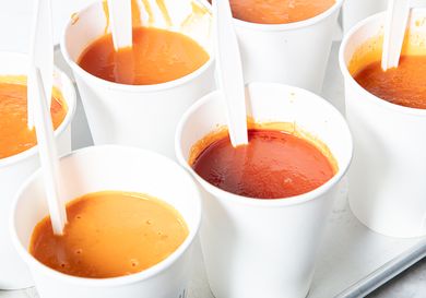 Cups of tomato soup with spoons presented for a taste test