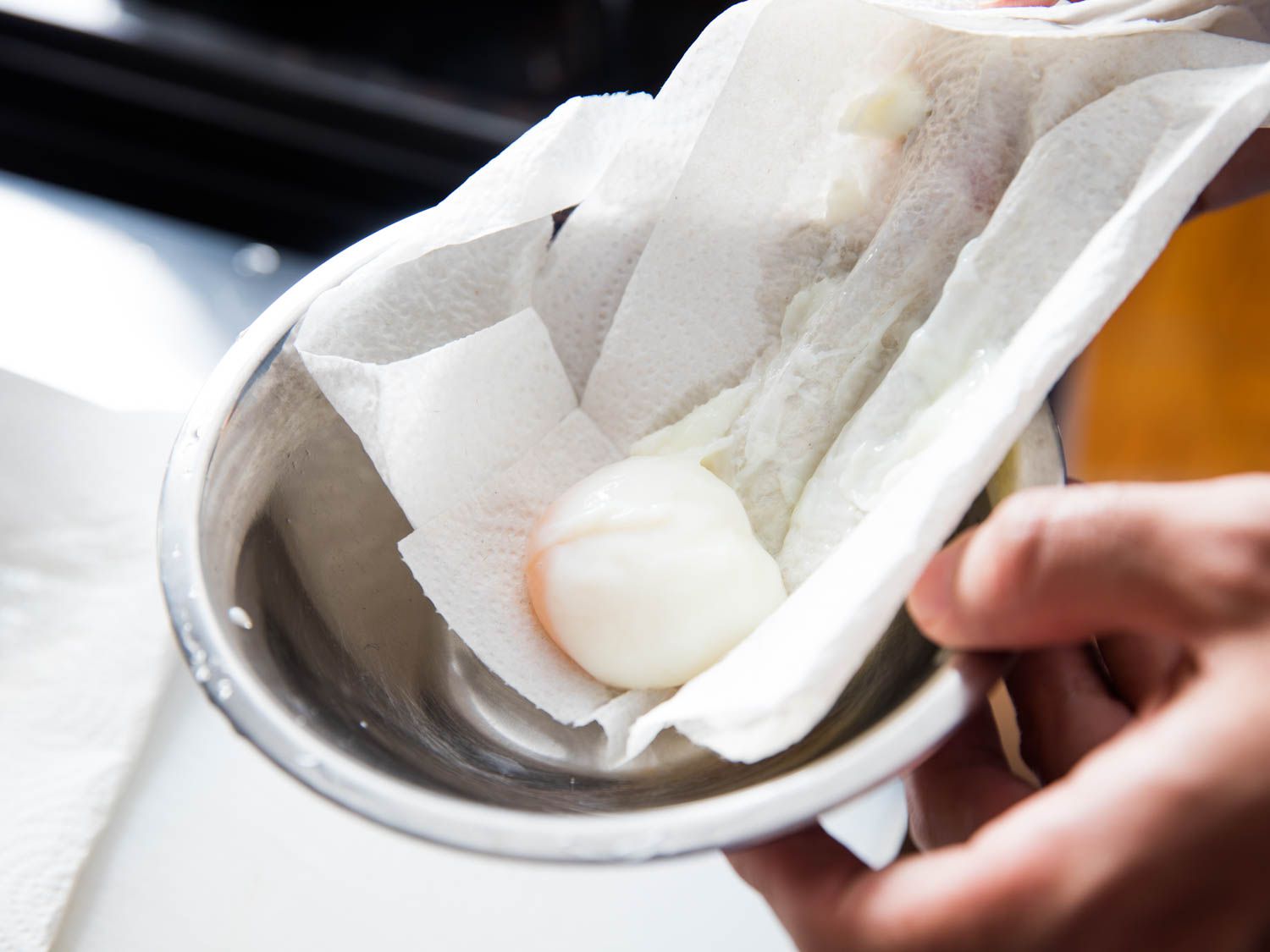 Author wiping stringy whites from onsen egg with paper towel.