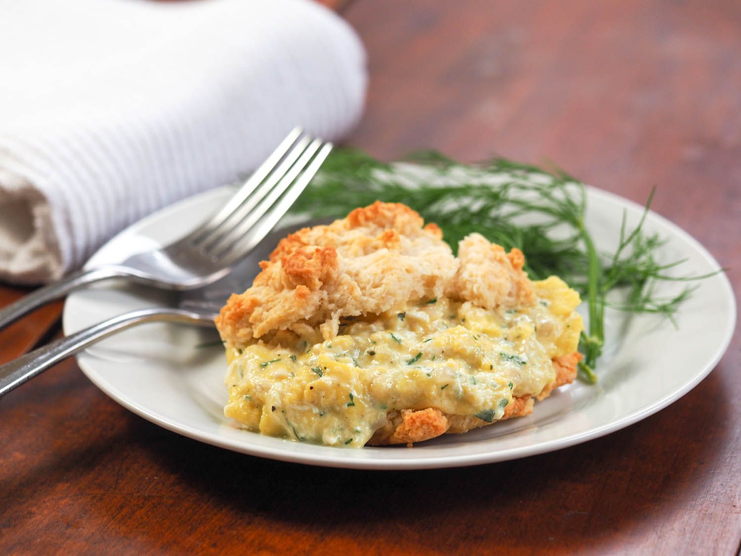 A scrambled egg and cheese drop-biscuit breakfast sandwich served on a plate.