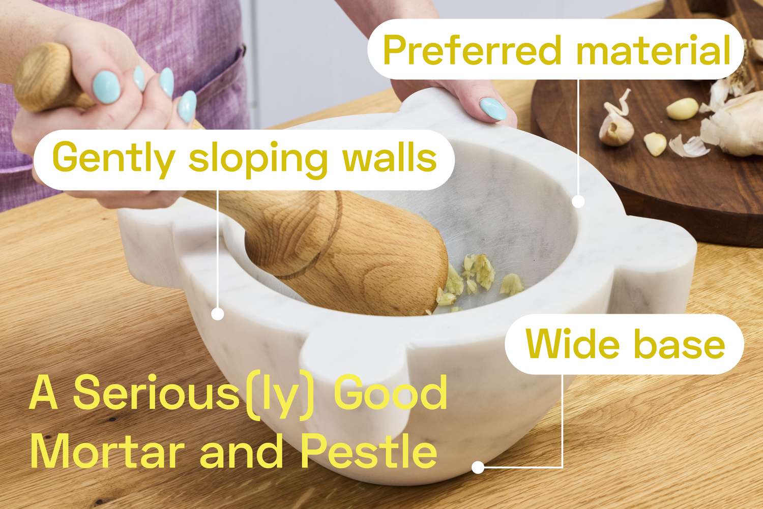 A person using a marble mortar and and pestle to smash garlic.