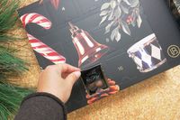 A hand opening a door of the Lakrids by Bülow Holiday Advent Calendar