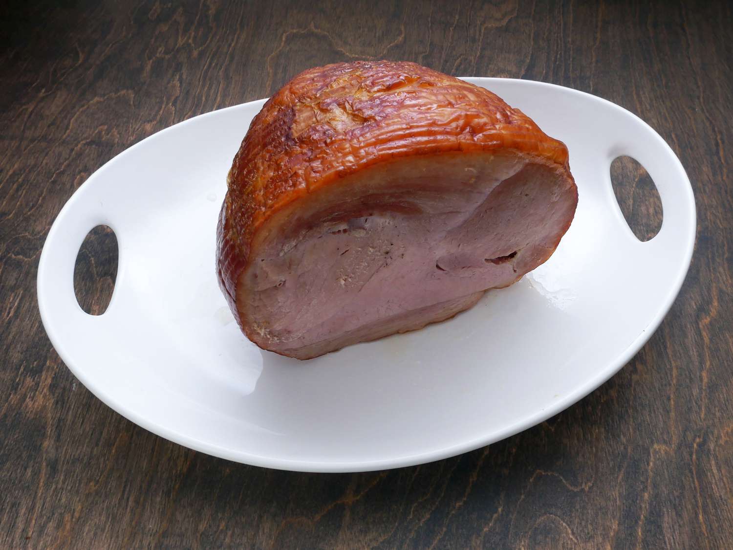 a half, boneless ham on a white platter