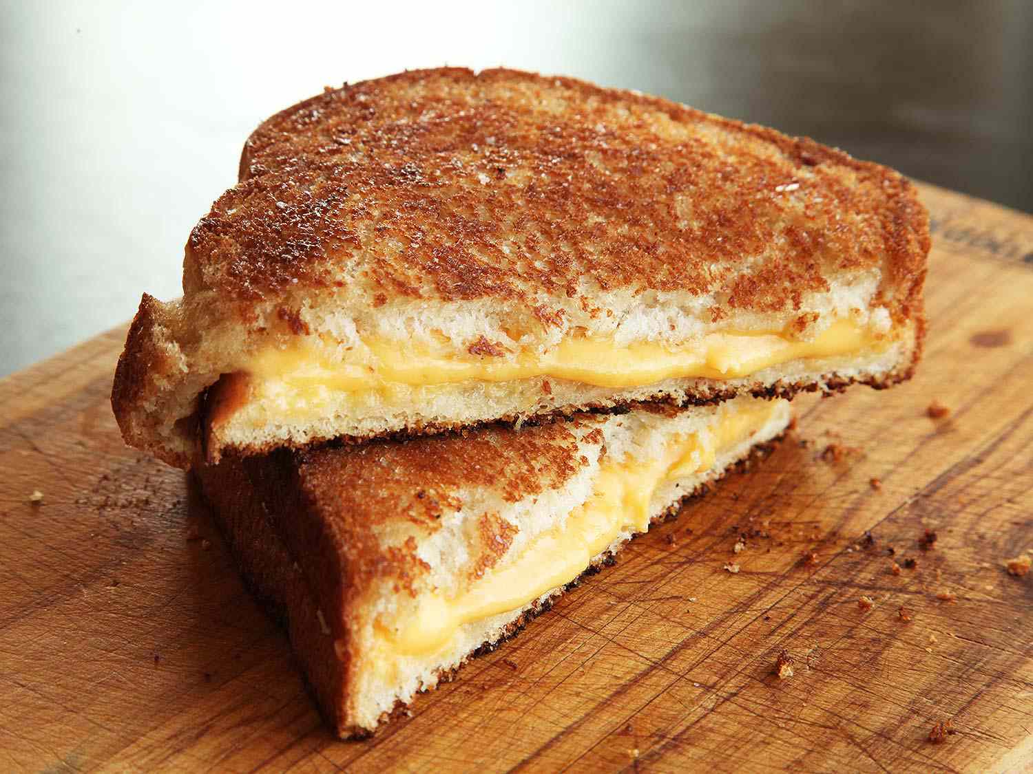A Grilled cheese sandwich cut in half on a cutting board