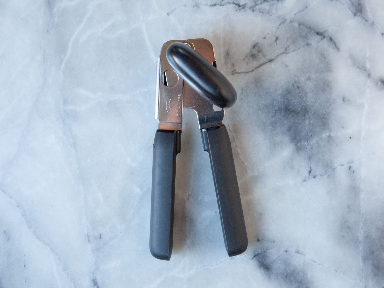 The OXO can opener on a marble surface