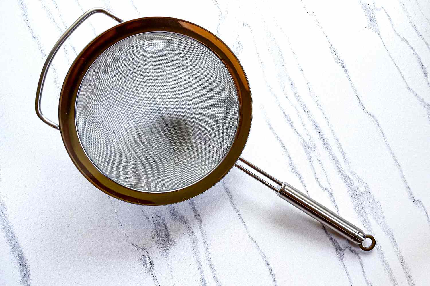 Rösle Stainless Steel Round Handle Kitchen Strainer on a marbled surface