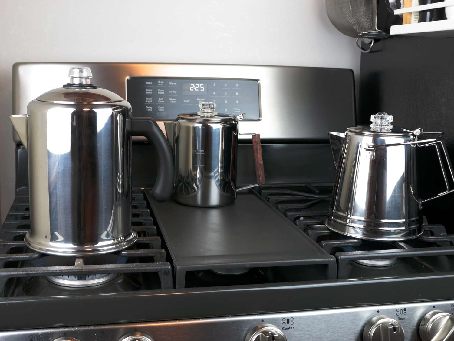 three different stovetop percolators on the oven