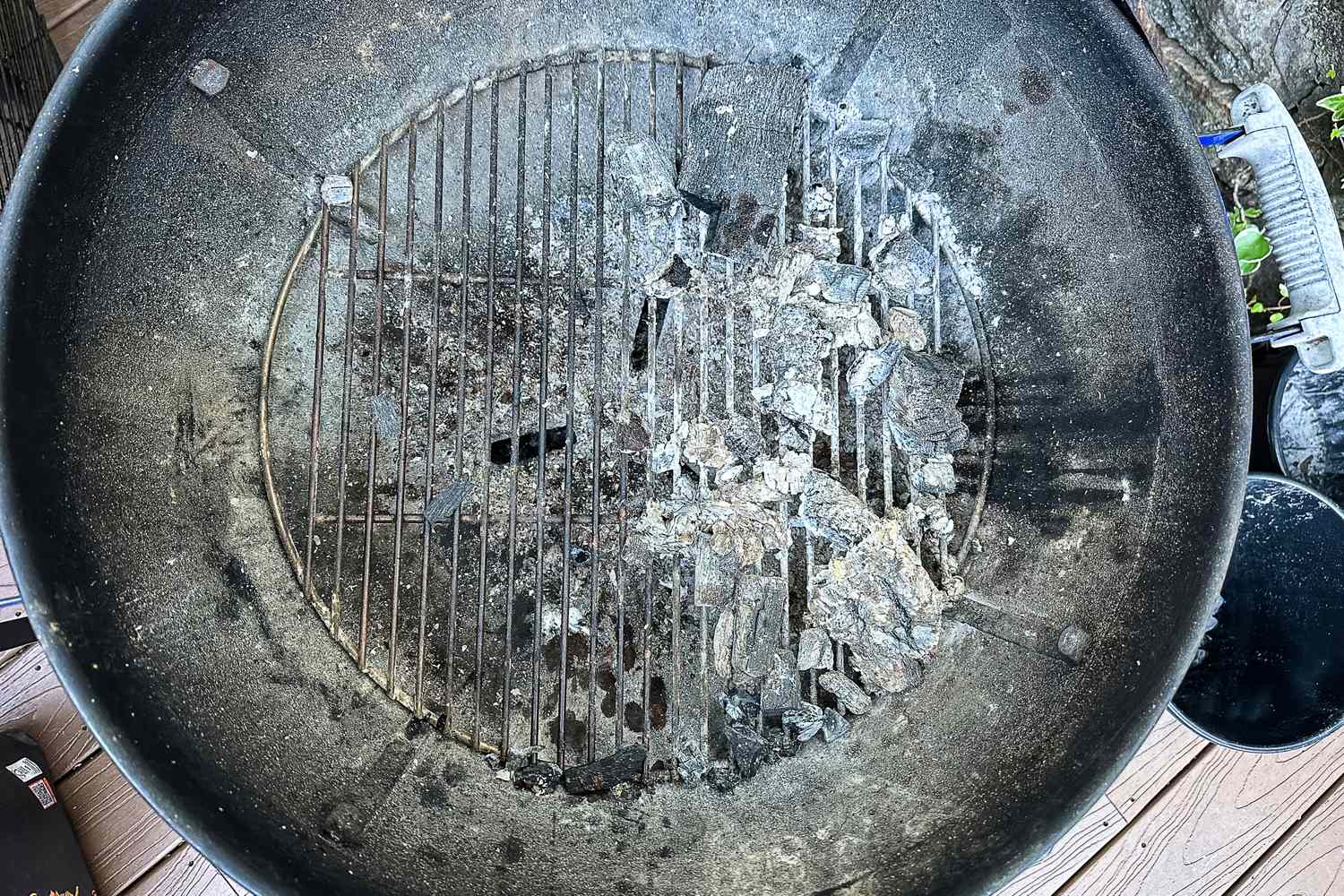 Top view of a barbecue grill withRoyal Oak All Natural Hardwood Lump Charcoal remains and ash on its grate
