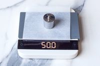 Acaia Lunar Scale displaying 50.0 with a metal weight placed on it
