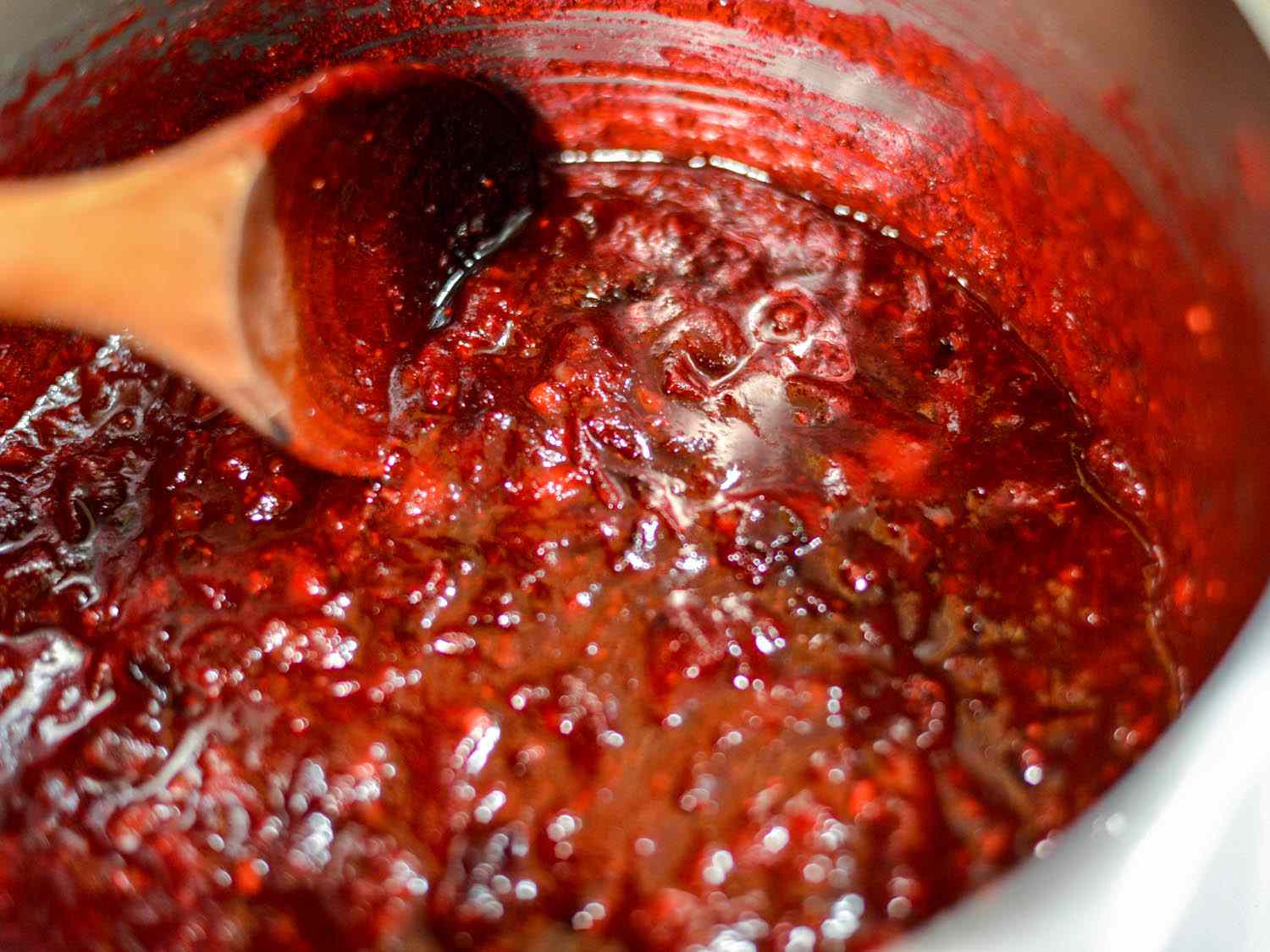 Cranberry sauce bubbling in a saucepan. 