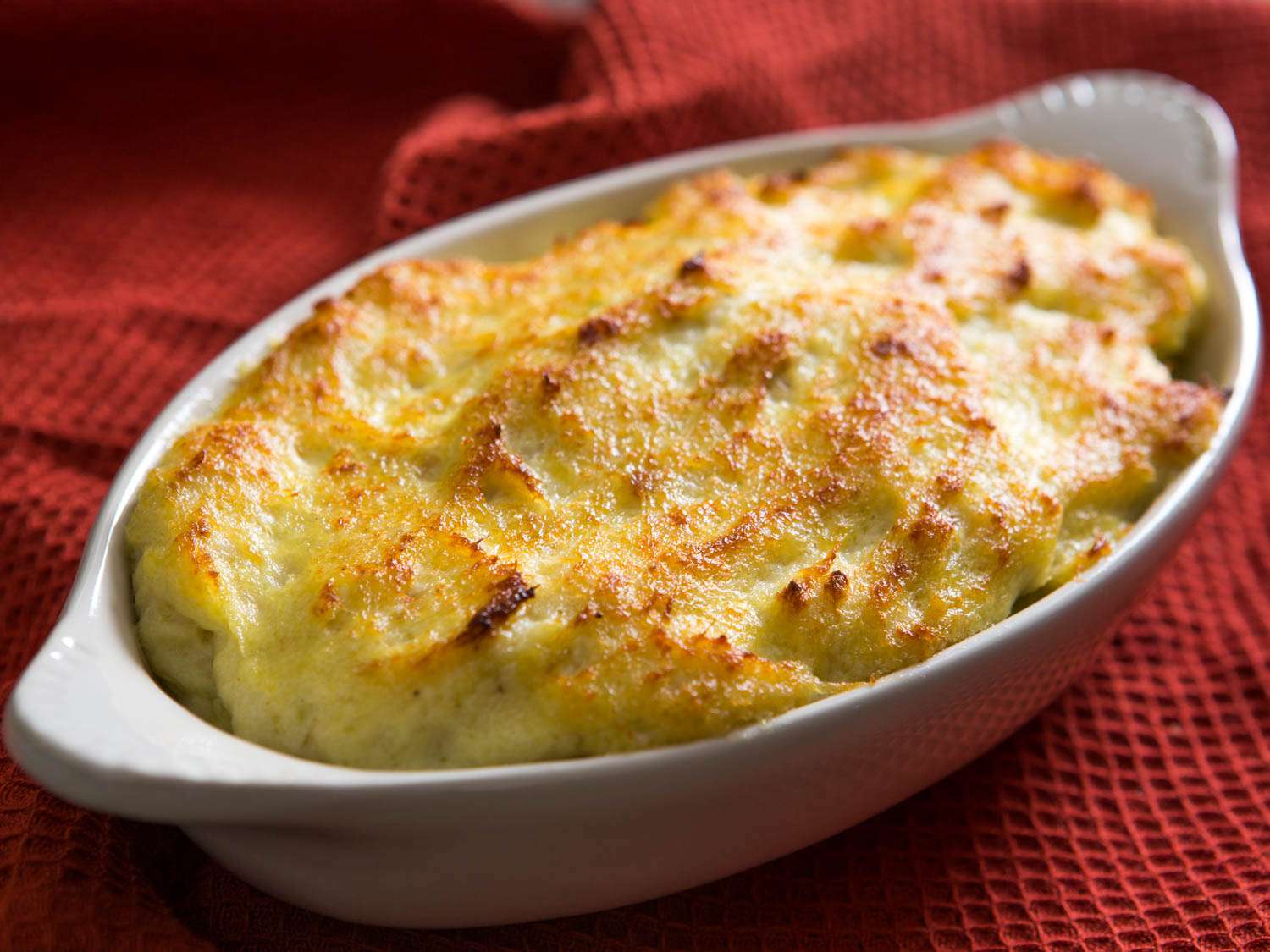 Closeup of a gratin dish of lightly browned brandade, fresh from the oven.