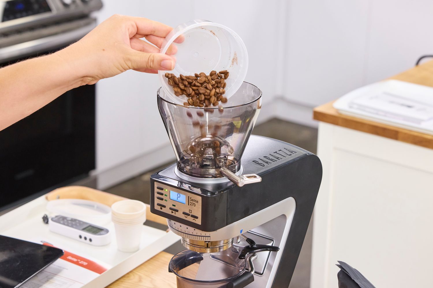 A person pours coffee beans into the Baratza Sette 270 Conical Burr Grinder