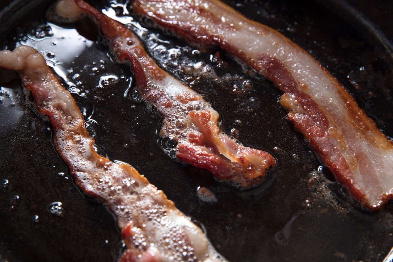 Bacon sizzling in a cast iron pan