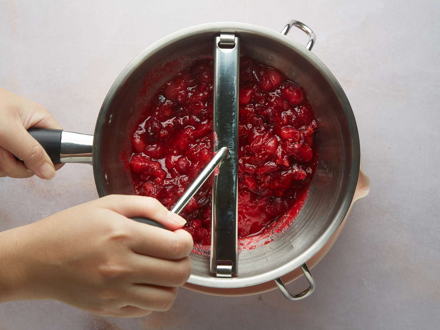 cranberry mixture being processed through a food mill 