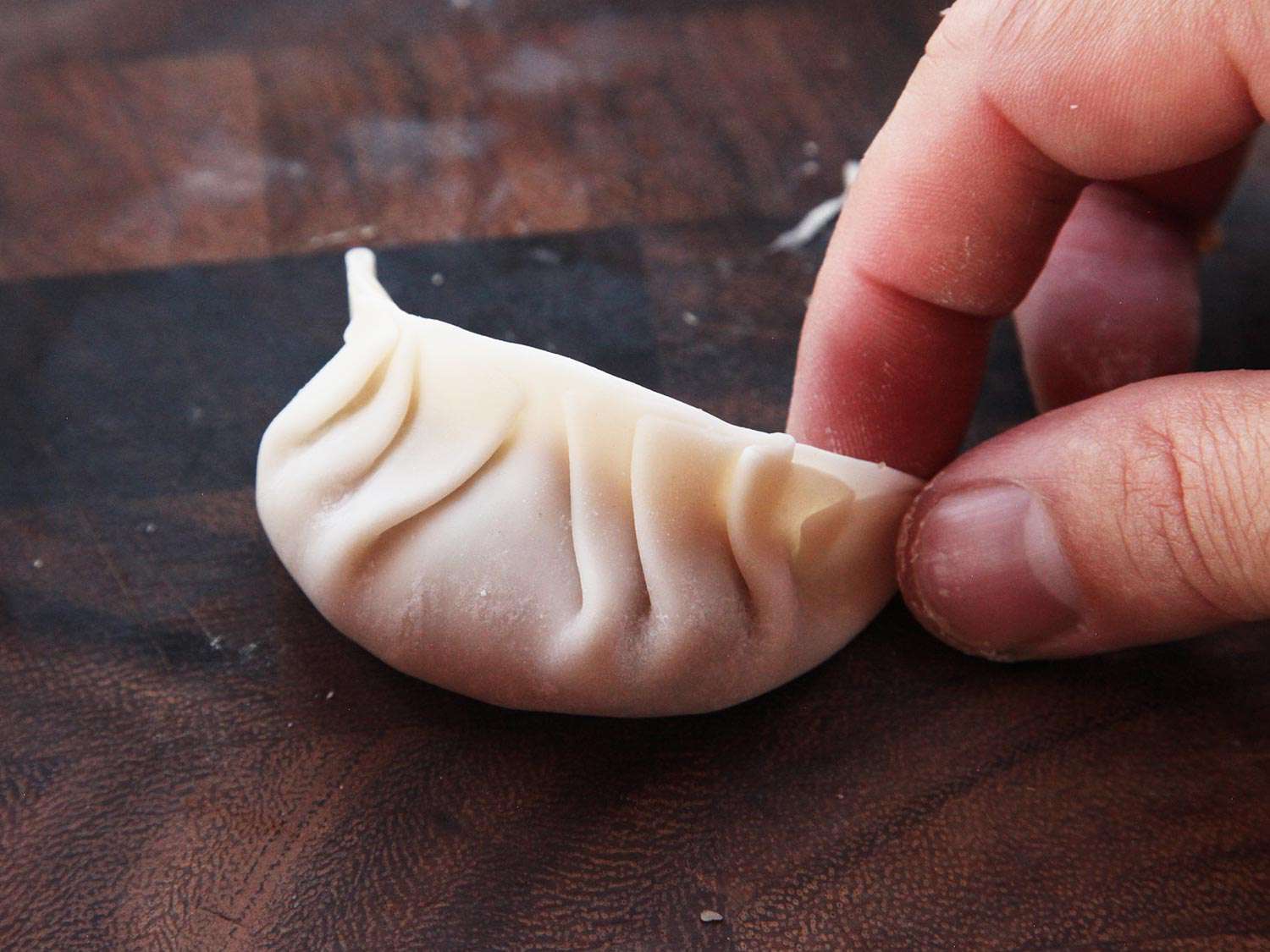 Plumping and shaping a just-filled and folded gyoza. 