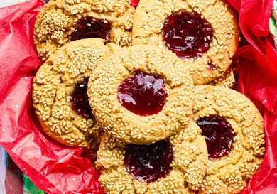 Thumbprint cookies with seeds and jam filling on red wrapping paper