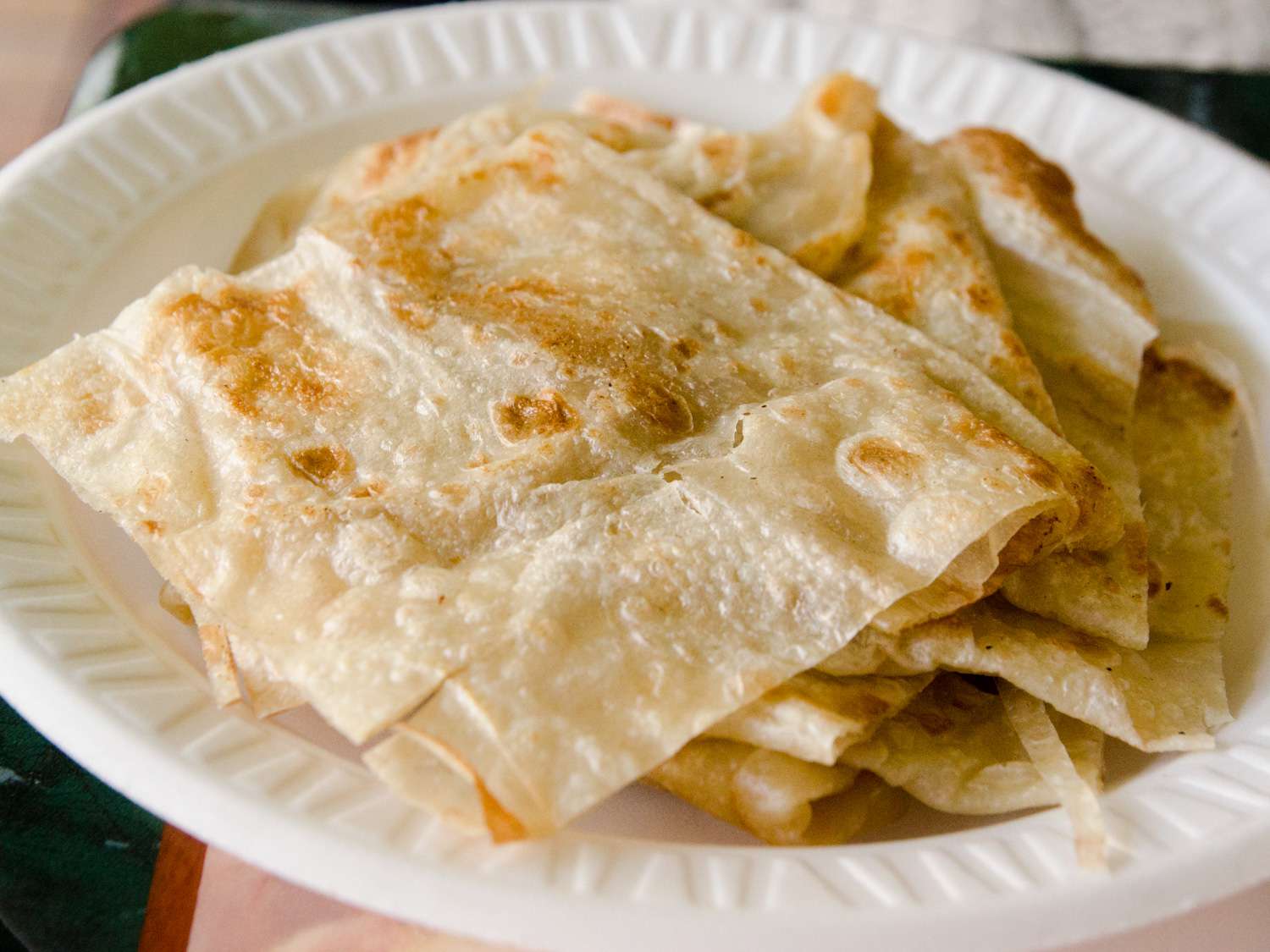 A small plate with a stack of roti. 
