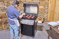A person grilling patties on the Weber Spirit EP-435 Gas Grill