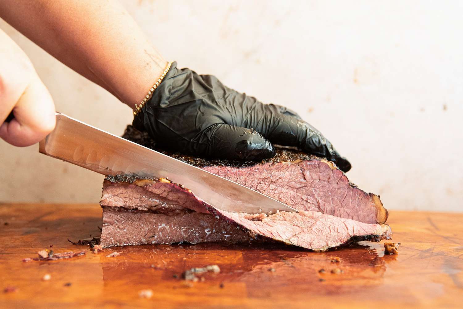 A person slicing meat using the Wusthof Classic Carving Knife