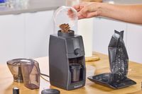 A person pours coffee beans into the Baratza Encore ESP Pro Coffee Grinder