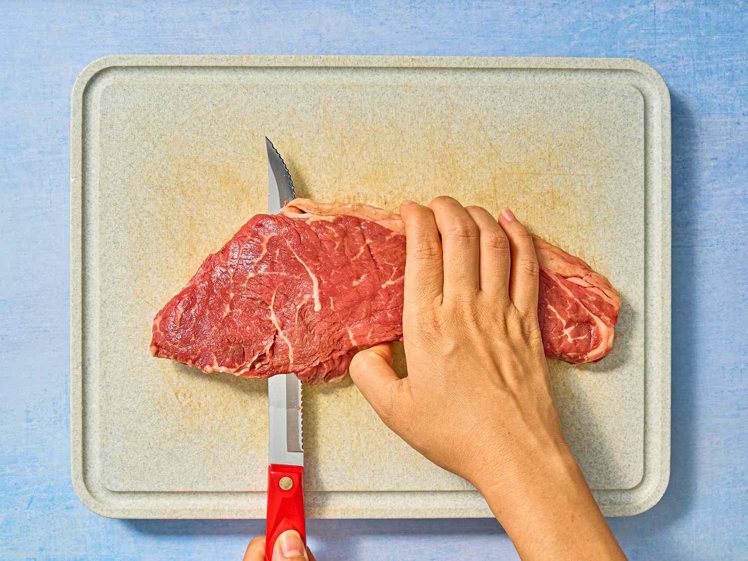 Steak on a chopping board being sliced open 