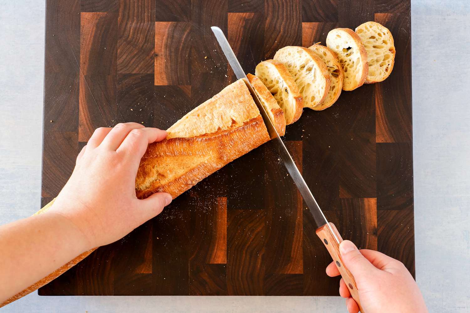 Person slicing bread with Tojiro F-737 Bread Slicer