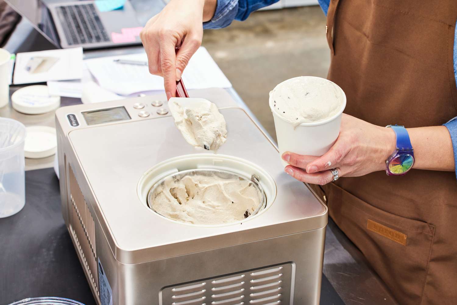A person using a spatula to spoon ice cream out of the Whynter 2-Quart Ice Cream Maker and into a container