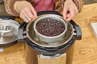 A person removes a cake from the Instant Pot Pro Plus Wi-Fi Smart 10-in-1 6-Quart Pressure Cooker